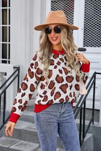Close-up of stylish women's leopard print sweater featuring vibrant red ribbed trim.