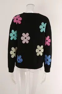 Detailed back view of a black knitted sweater featuring vibrant multi-color floral patterns