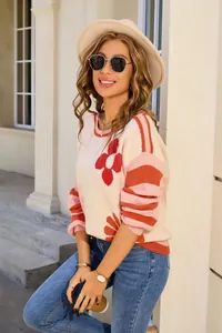 Detailed shot of a stylish oversized floral and striped round neck knit sweater