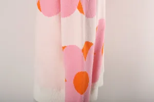 Macro view of women's floral knit sweater showing soft fabric texture and pink pattern