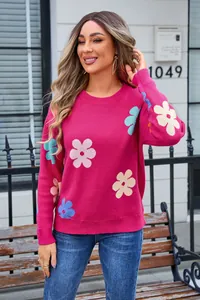 Detailed shot of a vibrant magenta knit sweater with colorful floral patterns on model.