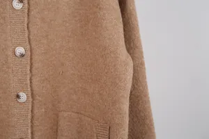 Detailed close-up view of camel knitted cardigan showing soft fabric and buttons.