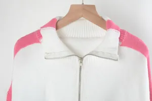 Detail van de wit en roze gebreide trui met een zilveren kraag met ritssluiting