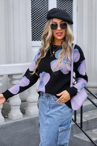 Detailed view of women's round neck knit sweater featuring large purple floral prints