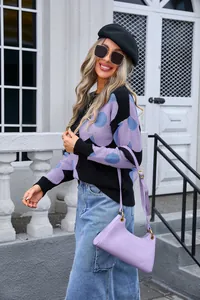 Outdoor lifestyle shot of a woman wearing a black floral print knit sweater
