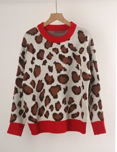 Detailed view of women's oversized leopard print sweater with vibrant red ribbed edges.