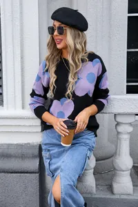 Stylish women's black sweater with large purple floral prints in a casual outdoor setting.
