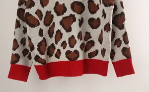 Macro detail showing leopard print knit and red ribbed hem of women's pullover sweater