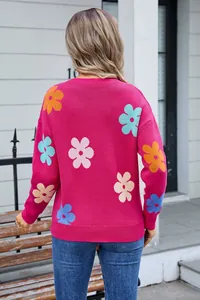 Back view of a vibrant pink knitted sweater featuring colorful floral patterns for spring fashion.