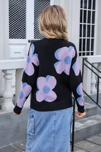 Back view of black knit sweater featuring large purple and blue floral print motifs.