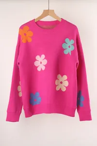 Vibrant pink crewneck knitted sweater featuring colorful floral patterns and ribbed cuffs.