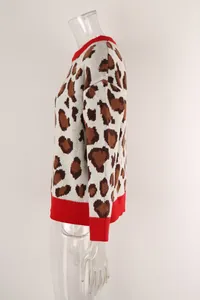 Detail side view of women's leopard print knitted sweater featuring red ribbed trim