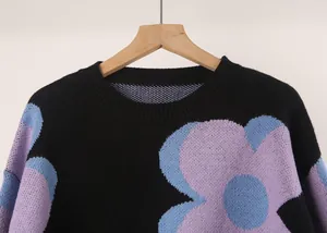 Close-up of a women's crew neck sweater featuring a soft knit texture and large floral patterns.