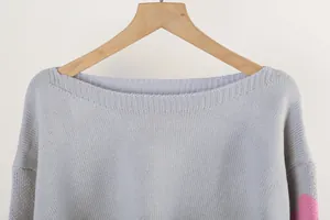 Close-up detail of grey boat neck knit sweater showing high-quality texture and finish