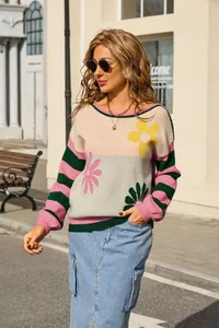 Detail shot of women's floral stripe knitted sweater worn in a stylish urban street setting