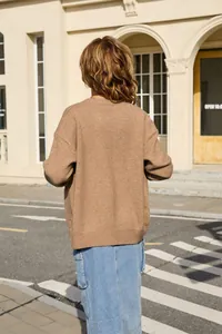 Back view of a casual brown knitted sweater for women shown in a street lifestyle setting