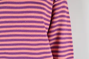 Detailopname van de zachte paars en roze horizontaal gestreepte gebreide stof trui