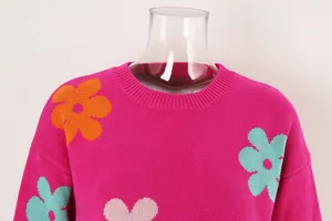 Detailed macro view of vibrant pink knit sweater featuring floral and heart motifs