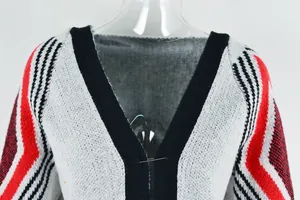Close-up detail of the V-neckline and knit texture on a long fringed cardigan sweater.