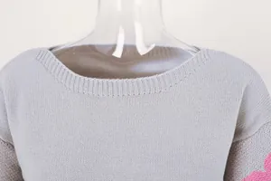 Close-up detail of grey boat neck knitted sweater showing fine ribbed neckline texture