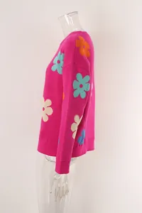 Side detail of a pink knit sweater featuring vibrant multi-color flower patterns for women
