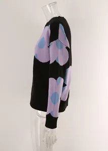 Side view of women's black crew neck sweater with large purple floral knit patterns