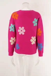 Detailed back view of a pink knit sweater with colorful floral patterns and crew neck