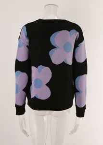 Detail view of a black crewneck sweater featuring large purple floral patterns.