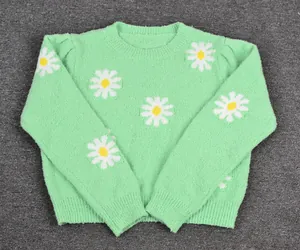 Mint green knitted sweater featuring white daisy patterns and a classic round neck.