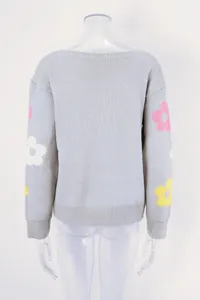 Back detail view of a grey knit sweater featuring colorful flower patterns on sleeves