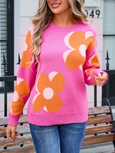 Detail of pink knitted sweater with large orange floral patterns and crew neck