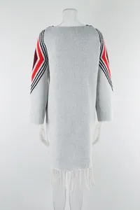 Grey long knit sweater dress featuring red geometric sleeve patterns and fringe hem