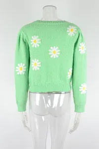Detailed back view of a vibrant green knitted sweater featuring white daisy patterns.