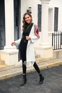 Close-up of women's white long fringed cardigan with red geometric sleeve details