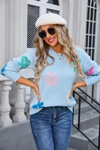 Detail of light blue crew neck knitted sweater featuring vibrant multi-colored flower patterns