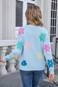 Back view of a light blue crew neck knit sweater featuring colorful floral patterns