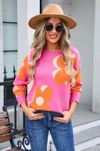 Fashion model wearing a pink round neck sweater with large orange flower patterns