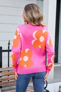 Back view detail of a vibrant pink knit sweater featuring large orange floral prints
