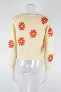 Detailed back view of a cream knit sweater with red daisy flower patterns on a mannequin
