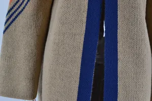 Macro detail of a long khaki knitted cardigan with blue stripes and premium wool texture