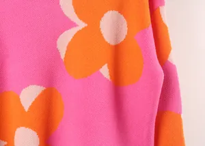 Close-up of pink knit sweater with large orange and light pink floral pattern texture
