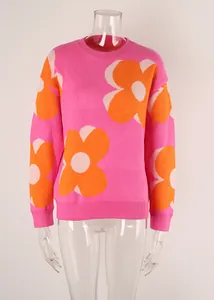 Close-up view of a pink women's knit sweater featuring large orange flower patterns