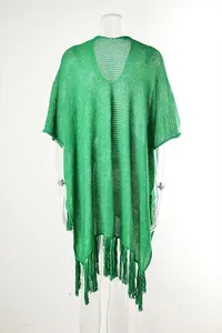 Close-up detail of green knitted beach cover-up with hollow-out texture and tassels