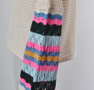 Detailed macro view of crochet beach cover-up sleeve featuring vibrant rainbow stripes.