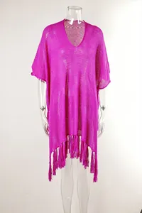 Macro detail of fuchsia hollow-out beach cover-up with decorative long fringe tassels.