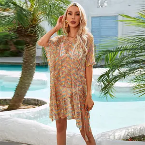 Detalle de una modelo con un vestido de ganchillo colorido para playa junto a la piscina