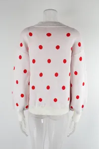 Detailed back view of a white oversized knit sweater featuring vibrant red polka dots