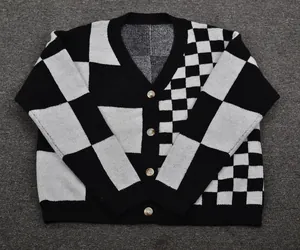 Detail view of a black and white checkered knit cardigan with a classic V-neck design