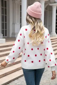 Back view detail of a cozy white knitted pullover sweater with classic red polka dot pattern