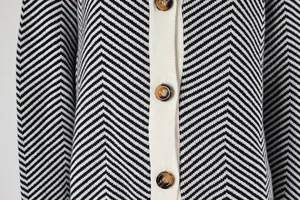 Macro detail of a women's chevron pattern knit cardigan with marbled brown buttons